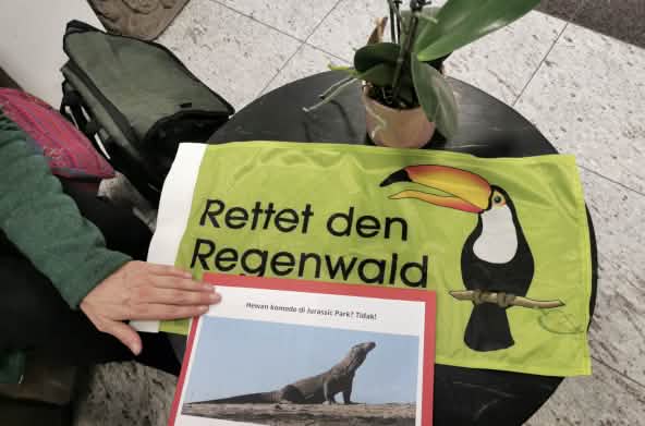 Rainforest Rescue banner and Komodo petition on a round table