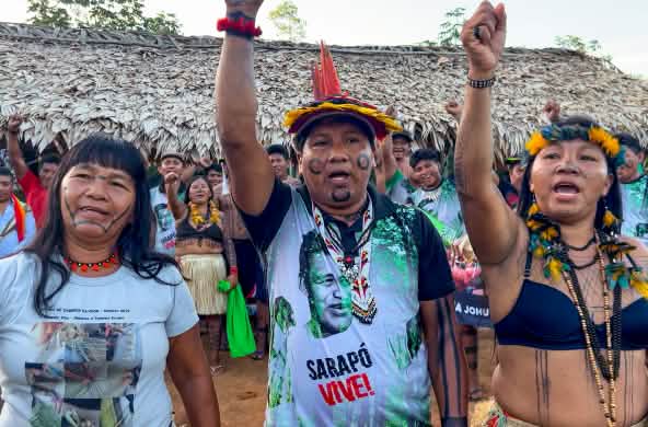 Three indigenous Ka'apor—two women and one man—with raised fists