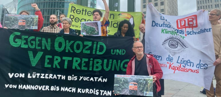 Demonstration in front of Deutsche Bahn headquarters at Potsdamer Platz in Berlin in late May 2024 A group of people protesting with large, colorful banners in front of three office buildings