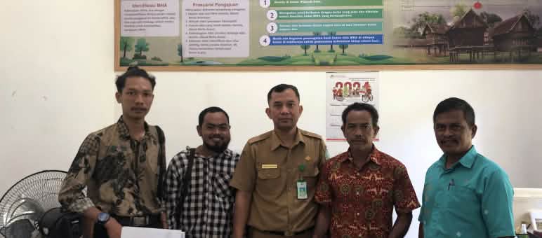 The path to protecting the rainforest is through the authorities Five men pose in the office of a government agency