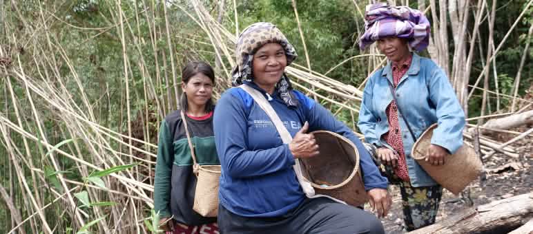 The rainforest gives us everything we need! Three Dayak women with collecting baskets smile at the camera.
