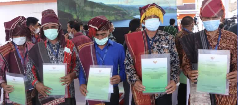 President Joko Widodo personally handed over the certificates recognizing the Indigenous forest Five men in Batak dress displaying certificates
