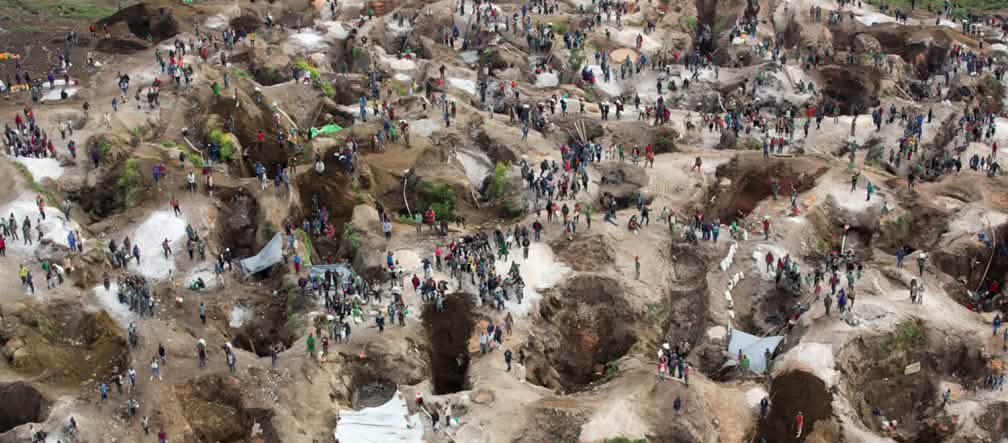 Coltan is one of the raw materials driving the violent conflicts in Congo Deep holes, some filled with water, with many people in between. View from above