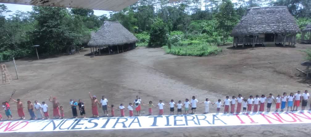 The Indians in Ecuador want to protect their rainforest Our land – nuestra tierra! Human chain with banner against land grabbing in Ecuador