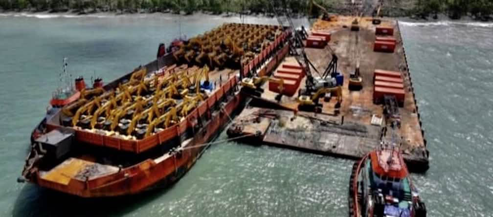 Heavy machinery for the destruction of forests in southern Papua Barge full of excavators