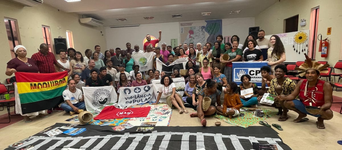 Group photo of around 50 people with banners in a seminar room