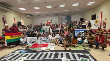 Group photo of around 50 people with banners in a seminar room