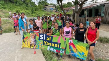 A group of people hold up a banner reading “Yes to Yasuní Manabí”