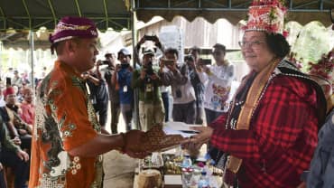 Willem Hengki and Siti Nurbaya, with numerous photographers in the background