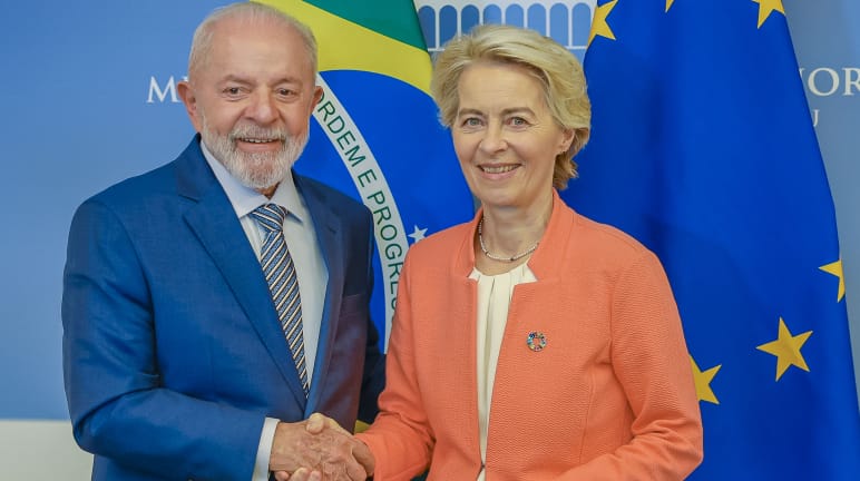 The President of the European Commission, Ursula von der Leyen, and Brazil’s President Lula da Silva shake hands in front of national flags