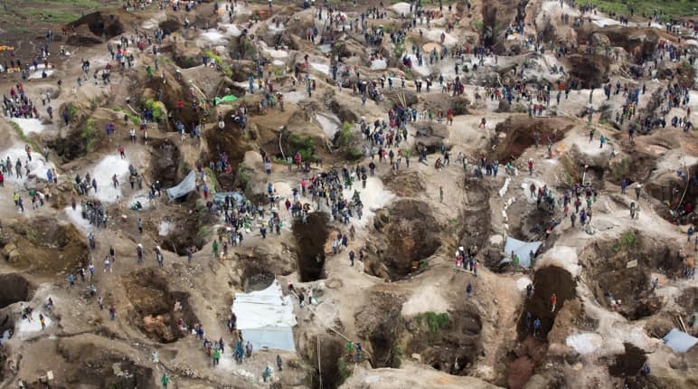 Deep holes, some filled with water, with many people in between. View from above