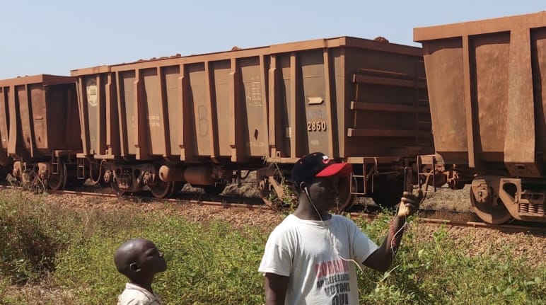 A freight train, a boy and a man in the foreground