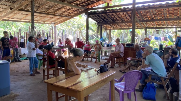 A group of people at a meeting in an open hut