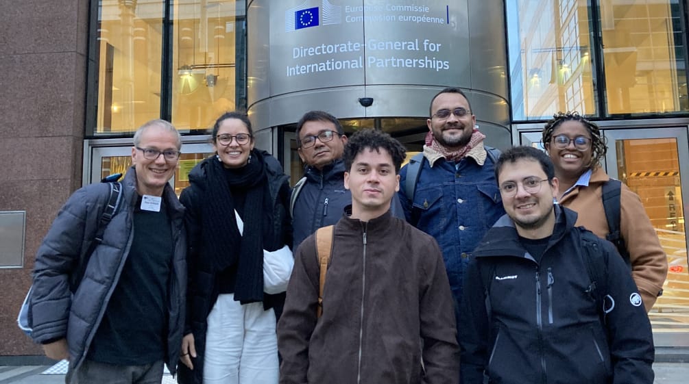 Group photo of seven people in front of the entrance of a building of the EU Commission in Brussels