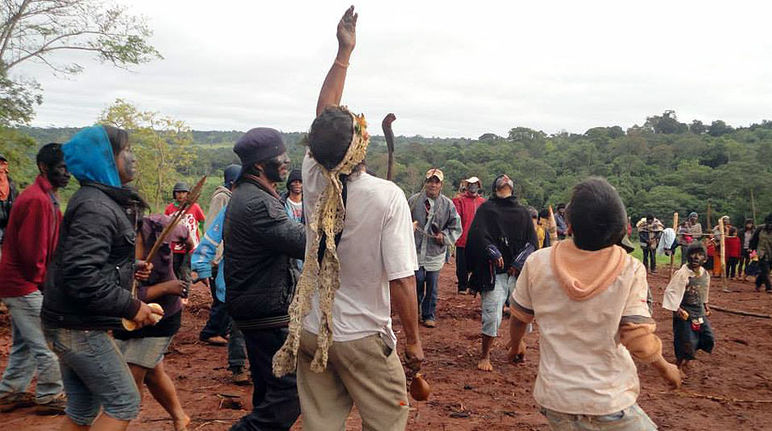 Members of the Avá Guaraní community dance amid the ruins of their temple